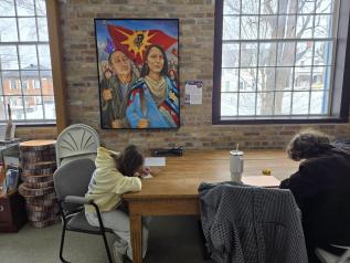 Students writing responses while viewing First Nations art